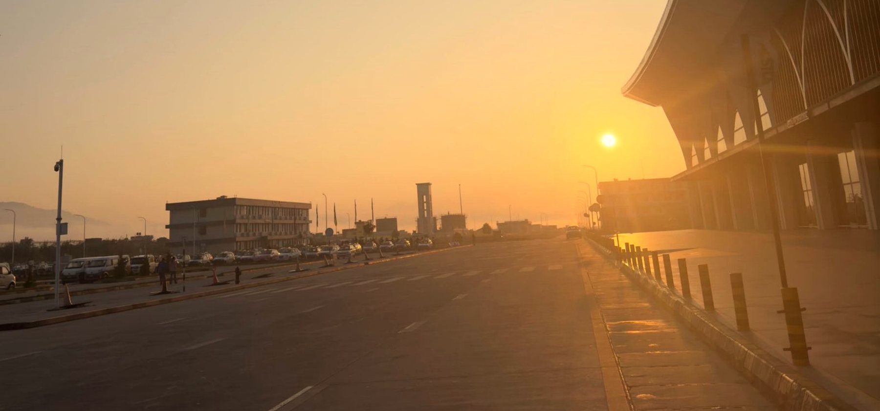 Terminal de aeroporto ao entardecer, com a via de embarque vazia