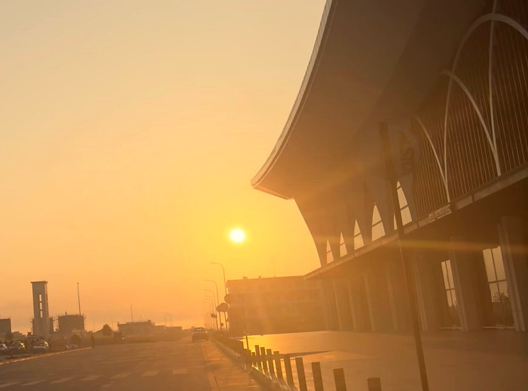 Fachada de um terminal de aeroporto contra o sol do fim de tarde